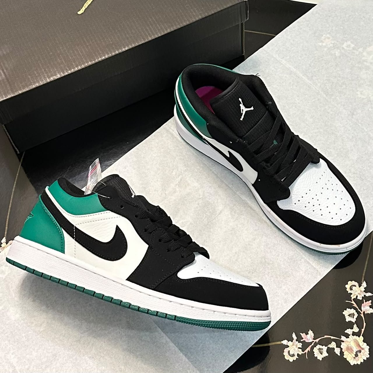 Green, black and white Jordan 1 Low sneaker, angled view